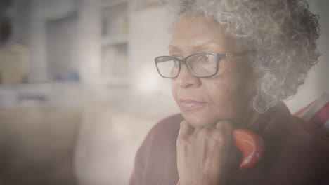 Animation-of-glowing-light-over-pensive-senior-woman-leaning-on-walking-stick