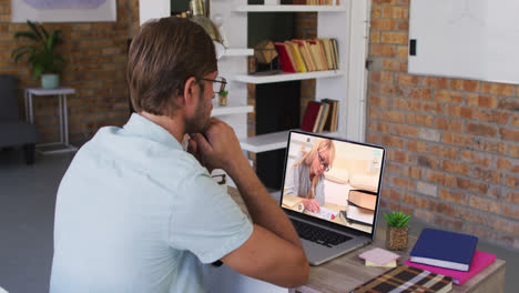 Caucasian-male-teacher-using-laptop-on-video-call-with-female-student