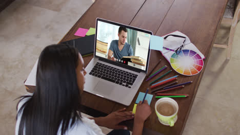 Caucasian-female-teacher-using-laptop-on-video-call-with-male-student,-making-notes