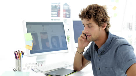 Handsome-young-creative-designer-phoning-with-his-phone-