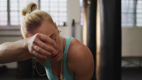 Tired-fit-caucasian-woman-taking-a-break-from-working-out-at-the-gym