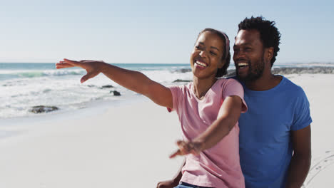 Pareja-Afroamericana-Sonriendo-Y-Abrazándose-En-La-Playa