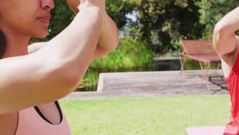 Diverse-group-practicing-yoga-pose-with-eyes-closed-in-sunny-park