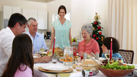 Mother-bringing-turkey-to-dinner-table-for-christmas