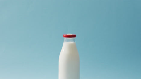 Video-of-glass-bottle-of-milk-on-blue-background