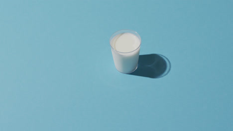 Video-of-glass-of-fresh-milk-over-blue-background