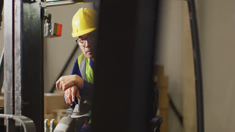 Portrait-of-asian-male-worker-wearing-safety-suit-in-warehouse