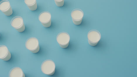 Video-of-row-of-glasses-of-milk-on-blue-background