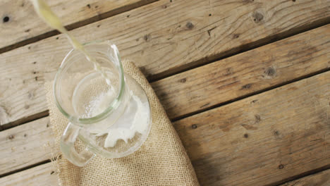 Video-of-glass-jug-of-milk-on-wooden-background