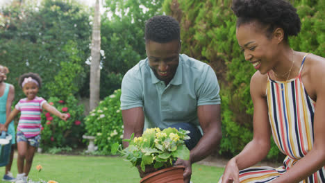 Feliz-Familia-Afroamericana-Sosteniendo-Regadera-Y-Trabajando-En-El-Jardín