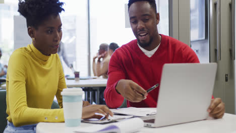 Colegas-De-Negocios-Afroamericanos,-Hombres-Y-Mujeres,-Hablando-Y-Usando-Una-Computadora-Portátil-En-La-Oficina