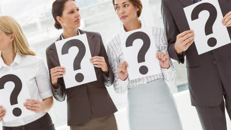 Confused-group-of-caucasian-businessmen-and-businesswomen-holding-question-mark-signs