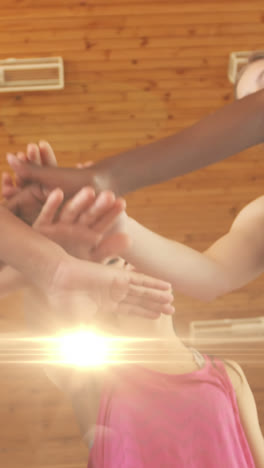 Animation-of-light-spots-over-diverse-schoolchildren-teaming-up-at-gym