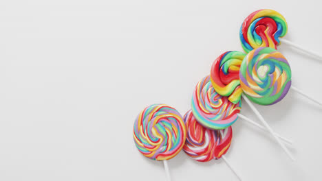 Video-of-rows-multicoloured-lollipops-on-white-background