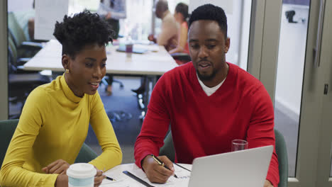 Colegas-De-Negocios-Afroamericanos,-Hombres-Y-Mujeres,-Hablando-Y-Usando-Una-Computadora-Portátil-En-La-Oficina