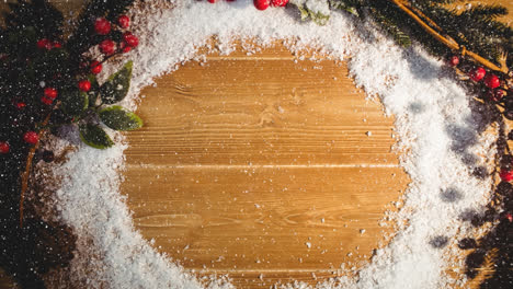 Snow-falling-over-traditional-christmas-decorations-on-wooden-surface