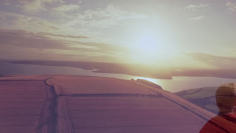 Composite-of-caucasian-senior-man-running,-with-sunset-over-beach-and-sea