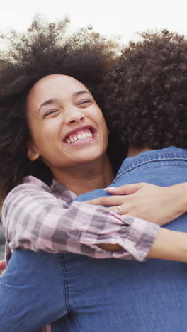 Biracial-couple-embracing-joyfully-outdoors