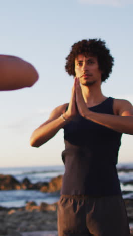 Young-biracial-man-practices-yoga-outdoors,-with-copy-space