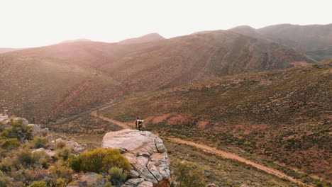 A-young-Caucasian-man-stands-on-a-rock-in-the-wilderness-with-copy-space