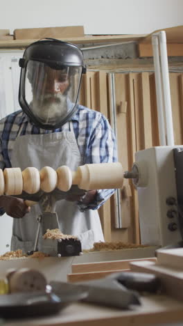 African-American-craftsman-shapes-wood-on-a-lathe-in-a-workshop