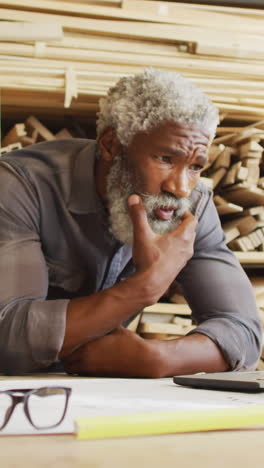 African-American-man-ponders-over-plans-at-a-workshop