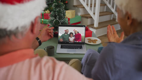 Feliz-Pareja-De-Ancianos-Caucásicos-En-Videollamada-Portátil-Con-Familia-En-Navidad