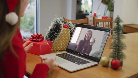 Kaukasische-Frau-Beim-Laptop-Videoanruf-Mit-Glücklicher-Freundin-Zur-Weihnachtszeit