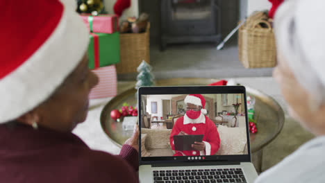 Verschiedene-ältere-Freundinnen-Nutzen-Laptop-Für-Weihnachtsvideoanruf-Mit-Dem-Weihnachtsmann-Auf-Dem-Bildschirm