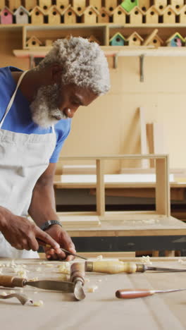 African-American-man-works-meticulously-in-a-woodworking-shop
