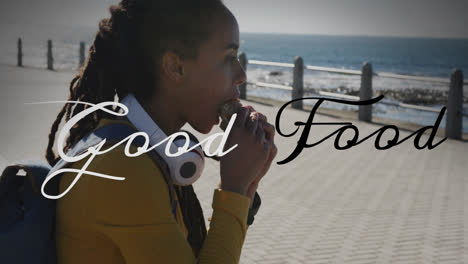 Animation-of-good-food-text-over-biracial-woman-sitting-and-eating-on-promenade