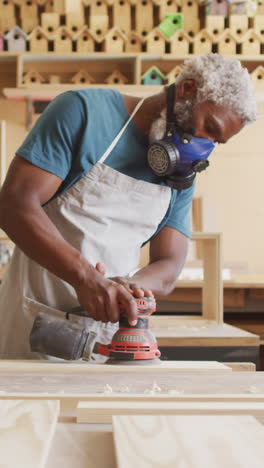 Afroamerikanischer-Handwerker-Schleift-Holz-In-Einer-Werkstatt