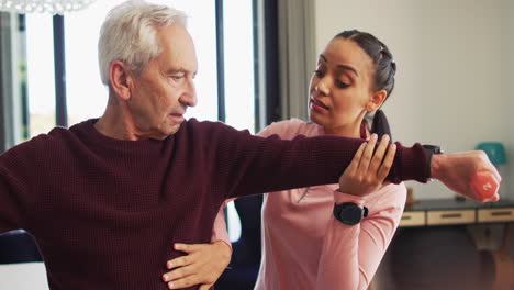 Älterer-Kaukasischer-Mann-Erhält-Unterstützung-Von-Einer-Jungen-Biracial-Weiblichen-Physiotherapeutin-Zu-Hause