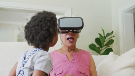 Feliz-Abuela-Afroamericana-Usando-Auriculares-Vr-Con-Su-Nieta-En-La-Sala-De-Estar