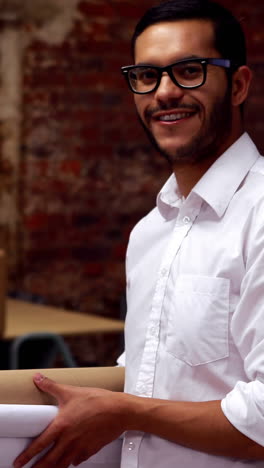 Vertical-video-of-a-biracial-man-smiling-in-an-office-setting