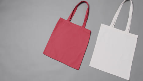 Close-up-of-red-and-white-bags-on-grey-background,-with-copy-space,-slow-motion