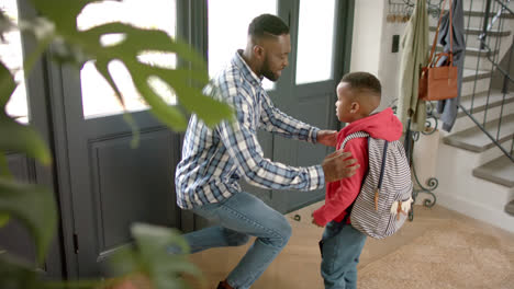 Feliz-Padre-Afroamericano-Despidiéndose-De-Su-Hijo-Antes-De-Salir-De-Casa-Para-Ir-A-La-Escuela,-Sembrar-Montion