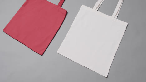 Close-up-of-red-and-white-bags-on-grey-background,-with-copy-space,-slow-motion