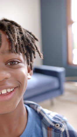 Video-Vertical-De-Retrato-De-Un-Feliz-Niño-Afroamericano-Sonriendo-En-Casa,-Cámara-Lenta