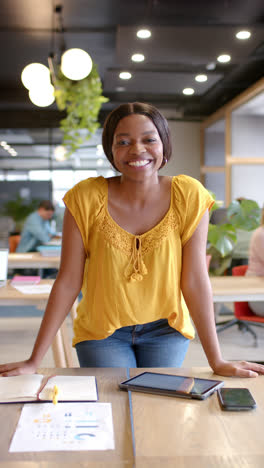 Vertikales-Video-Eines-Porträts-Einer-Glücklichen-Afroamerikanischen-Geschäftsfrau-Im-Büro-In-Zeitlupe