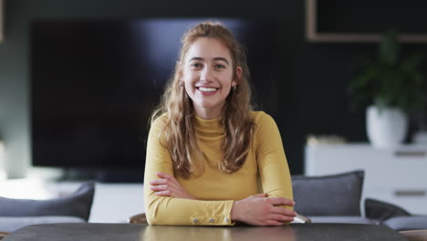 Happy-caucasian-woman-sitting,-smiling-and-having-video-call-in-sunny-house