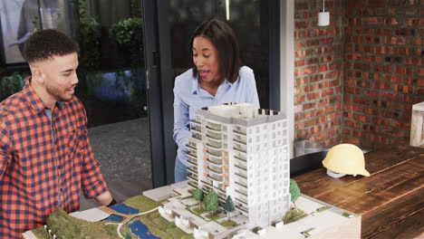 Diverse-male-and-female-architect-discussing-architectural-model,-slow-motion