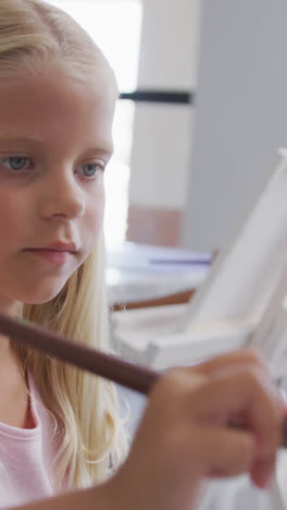 Video-of-focused-caucasian-girl-painting-during-art-lessons-at-school