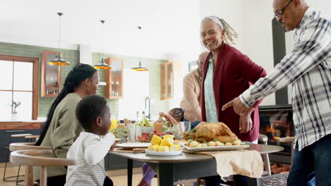 Fröhliche-Afroamerikanische-Mehrgenerationenfamilie,-Die-Essen-Beim-Thanksgiving-Dinner-Serviert,-Zeitlupe