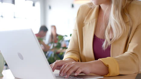 Feliz,-Pensativa-Mujer-De-Negocios-Casual-Caucásica-Usando-Laptop-En-La-Oficina,-Cámara-Lenta