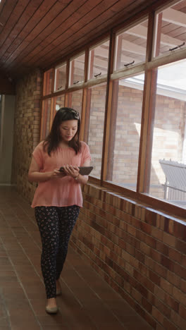 Vertical-video-of-portrait-of-happy-asian-female-teacher-with-tablet-in-slow-motion