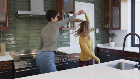 Feliz-Pareja-De-Lesbianas-Caucásicas-Abrazándose-Y-Sonriendo-En-La-Soleada-Cocina