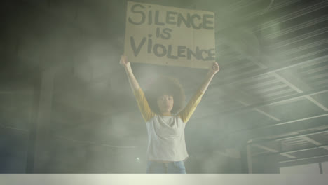 Young-biracial-activists-holding-cardboard-banners-in-protest-march