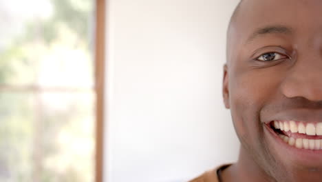 Half-portrait-of-happy-african-american-man-at-home-with-copy-space,-slow-motion