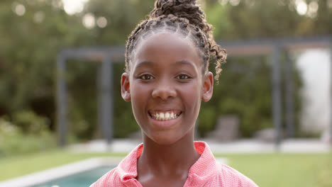 Portrait-of-happy-african-american-girl-smiling-in-garden,-in-slow-motion